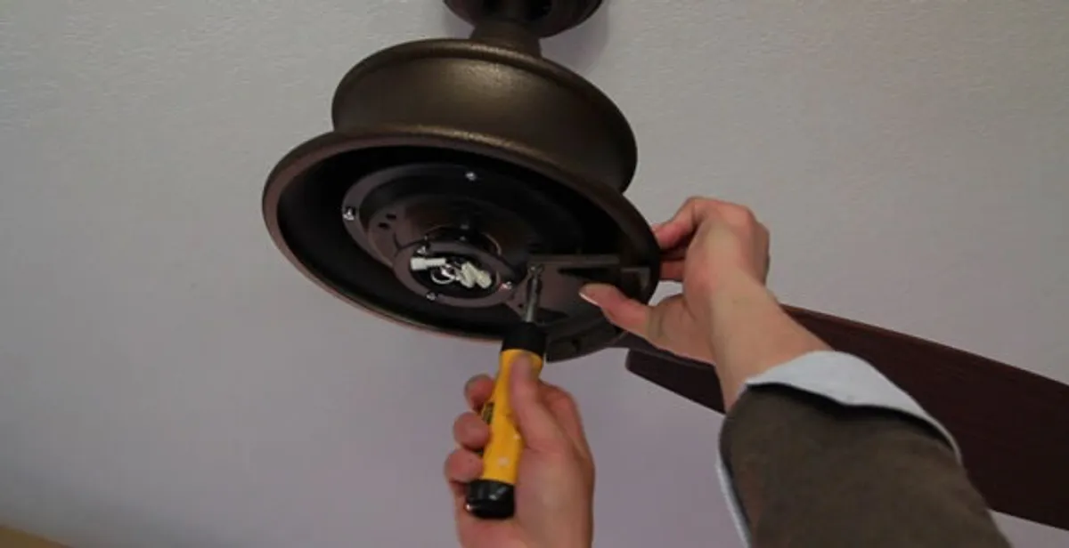 Electrician installing ceiling fan mounting bracket and fixture in Chicago, IL